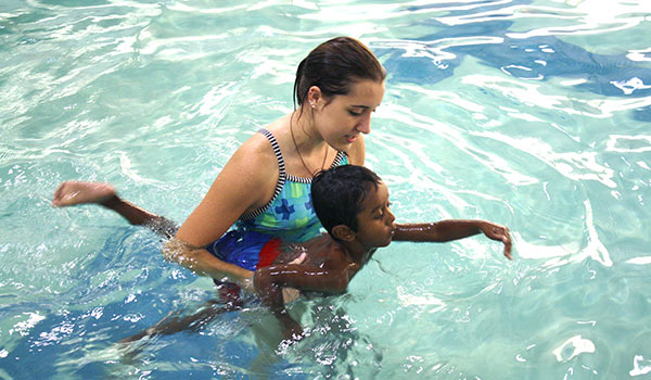 female instructor with young male child for swim lessons