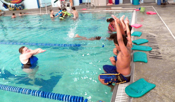 instructor with group of children for swim lesson